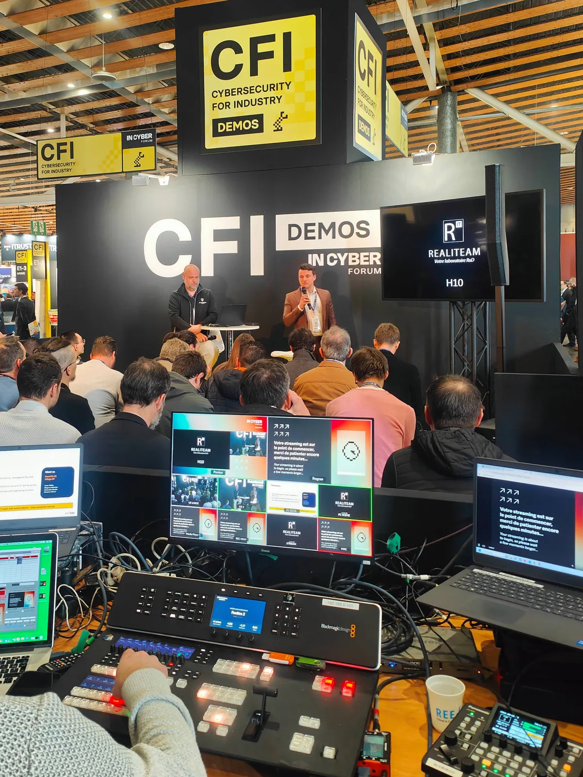 Animateur sur l'espace CFI Demos, avec la régie technique au premier plan